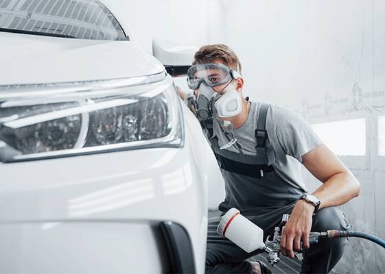 Auto body painter with respirator inspecting