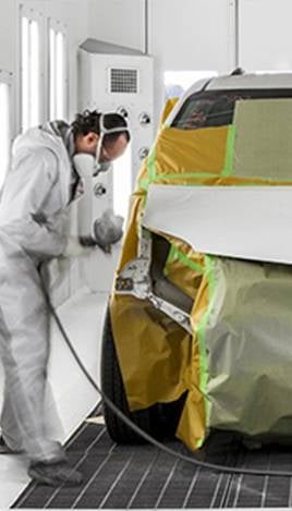 Auto body painter prepping car for paint